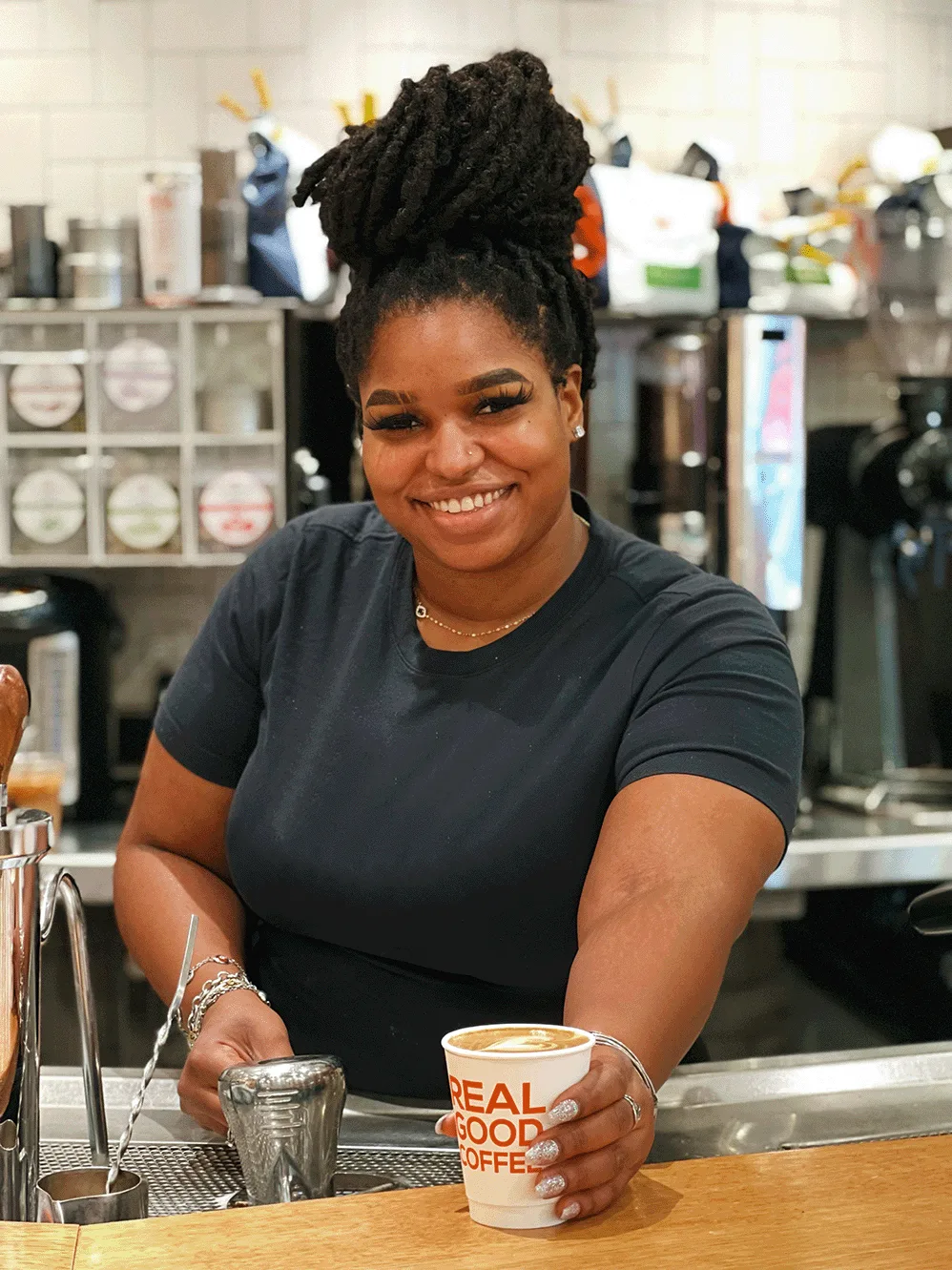 A Compass Coffee barista serving a drink